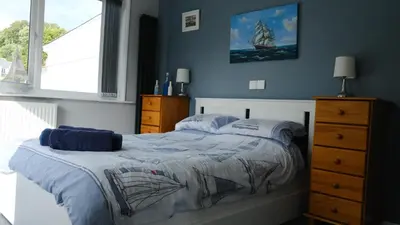 a bedroom with a bed and a dresser at Admirals Apartment 'As seen in Beyond Paradise ' sleeps 6 adults in Looe