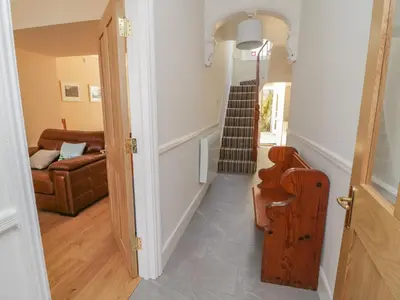 a hallway with a stairway leading to a living room at Pirate's Pad in St Austell