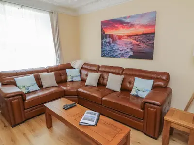 a living room with a brown leather couch at Pirate's Pad in St Austell