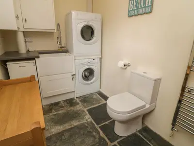 a bathroom with a toilet and a washing machine at Fairfield Cottage in Boscastle