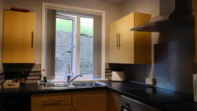a kitchen with a sink and a window at Commanders Cabin 'As seen in Beyond Paradise' in Looe