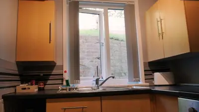 a kitchen with a sink and a window at Commanders Cabin 'As seen in Beyond Paradise' in Looe
