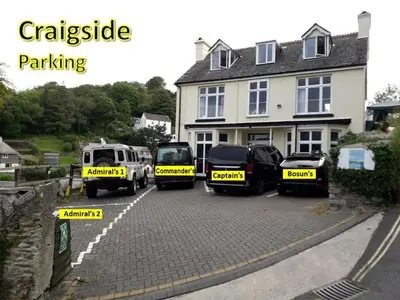 a group of vehicles parked in front of a house at Commanders Cabin 'As seen in Beyond Paradise' in Looe