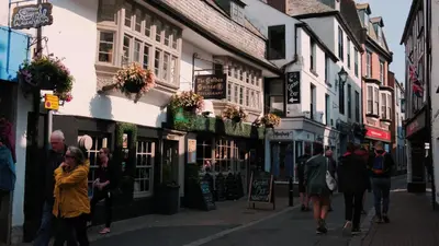 a group of people walking down a street with buildings at Captain's Quarters 'As seen in Beyond Paradise ' in Looe