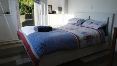 a bed with a blanket and pillows on it at Bosons Bunks 'As seen in Beyond Paradise ' in Looe