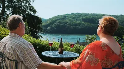 a man and a woman sitting at a table with wine glasses at Bosons Bunks 'As seen in Beyond Paradise ' in Looe