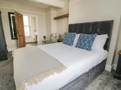 a bedroom with a large bed with blue and white pillows at Through The Porthole in Falmouth