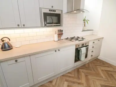 a kitchen with white cabinets and a counter top at Through The Porthole in Falmouth