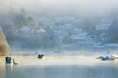 a group of boats on a lake in the fog at Redcliffe House in Looe