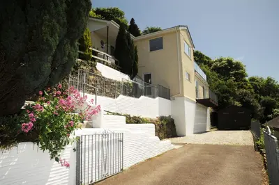 a white house with a white fence and stairs at Redcliffe House in Looe