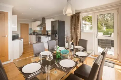 a dining room and kitchen with a table and chairs at Redcliffe House in Looe