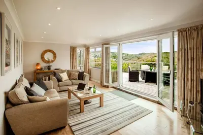 a living room with a couch and a table at Redcliffe House in Looe