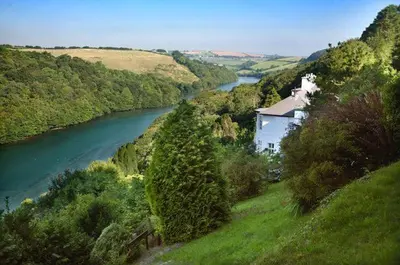a house on a hill next to a river at Redcliffe House in Looe