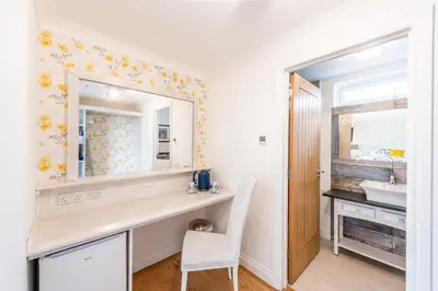 a bathroom with a vanity with a mirror and a sink at Mandalay in Bude