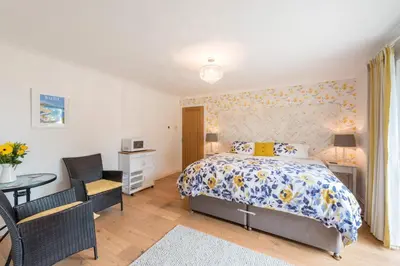 a bedroom with a bed and a table and chairs at Mandalay in Bude
