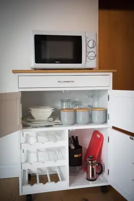 a white cabinet with a microwave on top of it at Mandalay in Bude