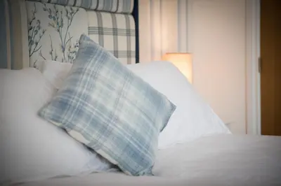 a blue and white pillow sitting on a bed at Mandalay in Bude