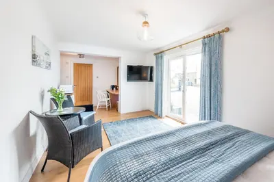 a bedroom with a bed and a table and chairs at Mandalay in Bude