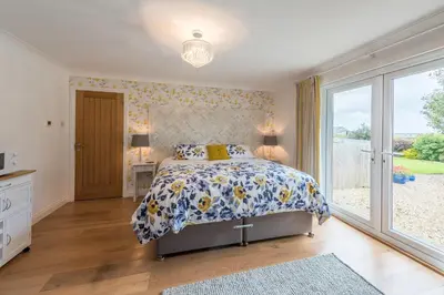 a bedroom with a bed and a large window at Mandalay in Bude