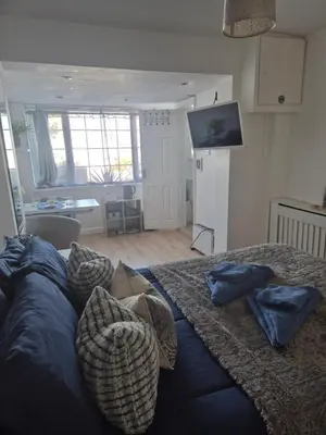 a bedroom with a bed with pillows and a television at Number 6 in St Austell