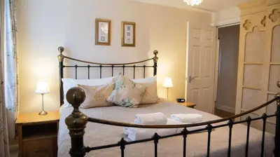 a bedroom with a bed and two lamps at Harbourside Apartment in Mevagissey