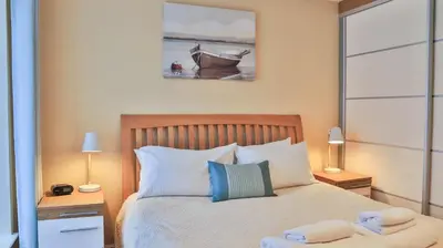 a bedroom with a bed with two night stands and two lamps at Harbourside Apartment in Mevagissey