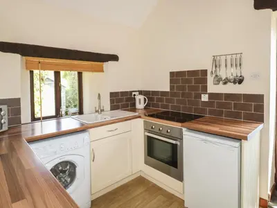 a kitchen with a washing machine and a sink at The Hayloft in Liskeard