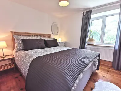 a bedroom with a large bed and a window at THE OLD RECTORY GLEBE HOUSE in Jacobstow 10 mins to Widemouth bay and Crackington Haven,15 mins Bude,20 mins tintagel, 27 mins Port Issac in Bude