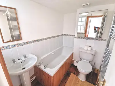 a bathroom with a tub and a toilet and a sink at THE OLD RECTORY GLEBE HOUSE in Jacobstow 10 mins to Widemouth bay and Crackington Haven,15 mins Bude,20 mins tintagel, 27 mins Port Issac in Bude