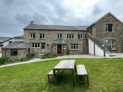 a stone house with a bench in front of it at THE OLD RECTORY GLEBE HOUSE in Jacobstow 10 mins to Widemouth bay and Crackington Haven,15 mins Bude,20 mins tintagel, 27 mins Port Issac in Bude