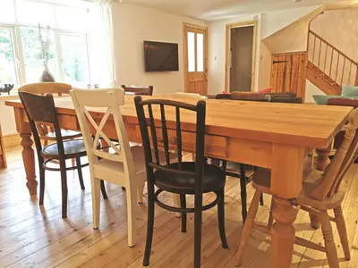a dining room with a wooden table and chairs at THE OLD RECTORY GLEBE HOUSE in Jacobstow 10 mins to Widemouth bay and Crackington Haven,15 mins Bude,20 mins tintagel, 27 mins Port Issac in Bude