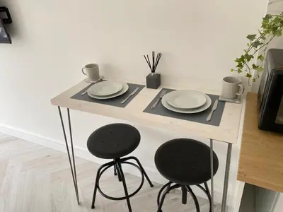a wooden table with two plates and two stools at Seaporth Studio St Ives in St Ives