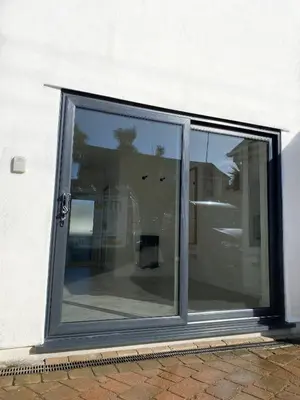 a sliding glass door on a building with reflections in it at Seaporth Studio St Ives in St Ives