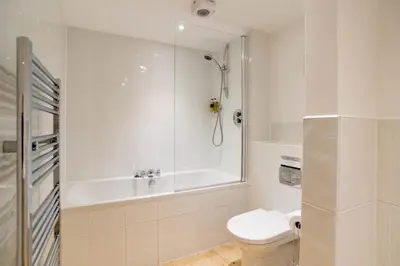 a bathroom with a tub and a toilet and a shower at Fistral Beach Garden Apartment 3 in Newquay
