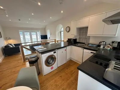 a kitchen with a washer and dryer in a room at The Old Bakery in Fowey