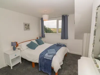 a bedroom with a bed and a window at Little Valley View in Hayle
