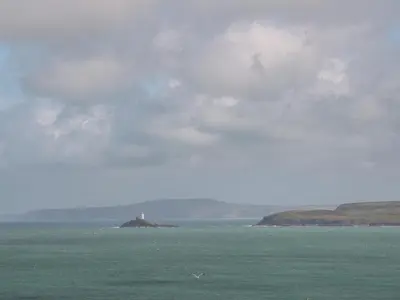a lighthouse on an island in the middle of the ocean at Little Valley View in Hayle