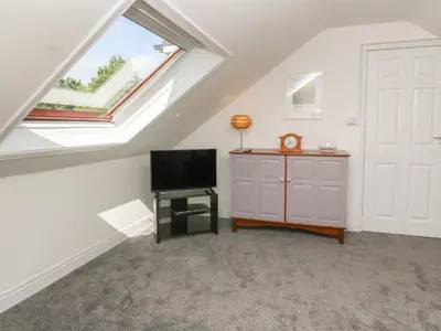 a attic room with a tv and a window at Little Valley View in Hayle