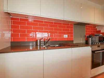 a kitchen with a sink and a red brick wall at Crantock Reach in Newquay