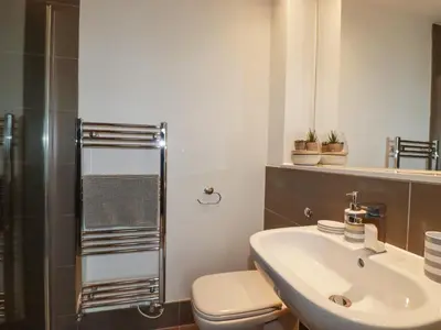 a bathroom with a sink and a toilet and a shower at Crantock Reach in Newquay