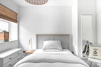 a bedroom with a bed and a desk and a window at The Gate Cornwall in Looe