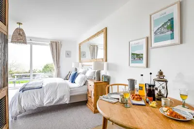 a bedroom with a bed and a table with food on it at The Gate Cornwall in Looe