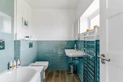 a bathroom with a toilet and a sink and a tub at The Gate Cornwall in Looe