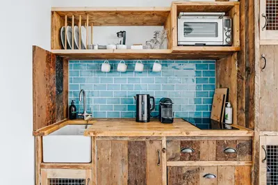 a kitchen with a sink and a microwave at The Gate Cornwall in Looe
