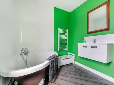 a green bathroom with a tub and a sink at By The Beach- Uk31201 in Downderry