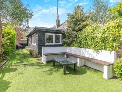 a backyard with a bench and a house at By The Beach- Uk31201 in Downderry