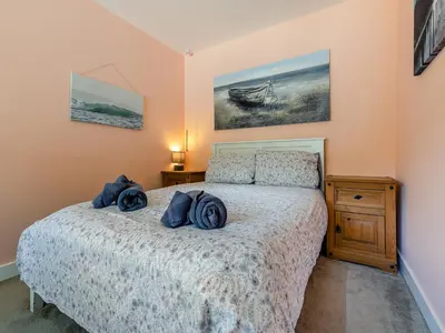 a bedroom with a bed with blue towels on it at By The Beach- Uk31201 in Downderry