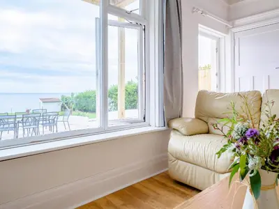 a living room with a couch and a large window at On The Beach, East Yardley House - Uk31203 in Downderry