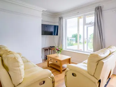 a living room with two chairs and a window at On The Beach, East Yardley House - Uk31203 in Downderry