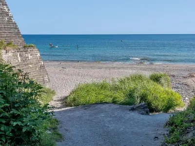 a sandy beach with people swimming in the ocean at On The Beach, East Yardley House - Uk31203 in Downderry
